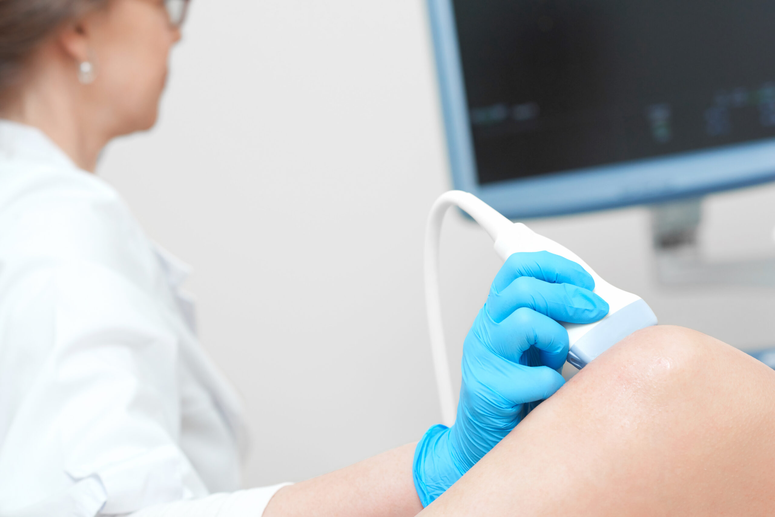 Woman getting knee ultrasound scanning examination at the clinic